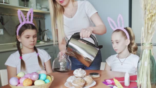 Boldog Húsvétot! Felkészítem a családot húsvétra. A nő teát főz a családjának üvegkannában. - Felvétel, videó