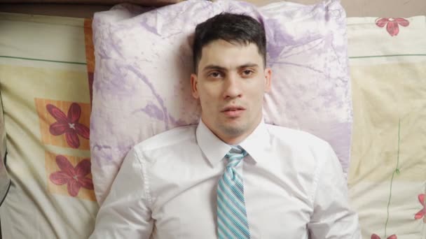 Fáradtan egy kemény nap után, egy férfi beleesik a kanapéba a tehetetlenségtől. Fáradtság - Felvétel, videó
