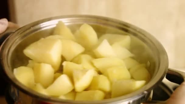 Enlevez l'eau chaude des pommes de terre dorées bouillies. Processus de cuisson des pommes de terre rôties au four parfaites - Séquence, vidéo