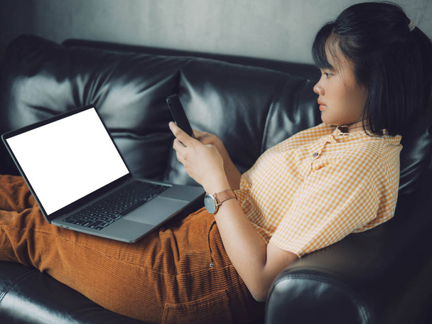 Azjatka używająca laptopa i smartfona w domu. Młoda azjatycka kobieta biznesu rozmawia smartfon i pracuje z labtop .Work w domu koncepcji. - Zdjęcie, obraz