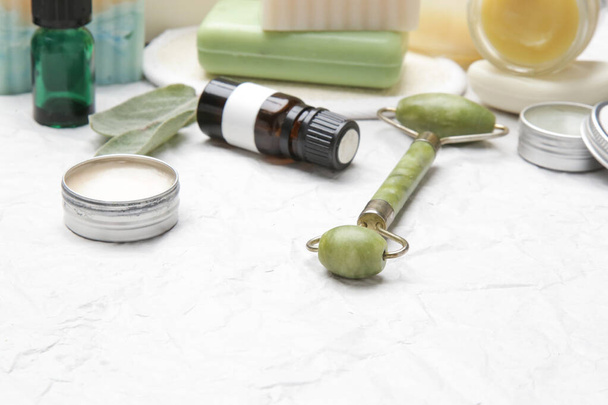 Natural organic skin care product. Home spa and self care concept. Facial serum, jade roller and soap bar with copy space. - Photo, Image
