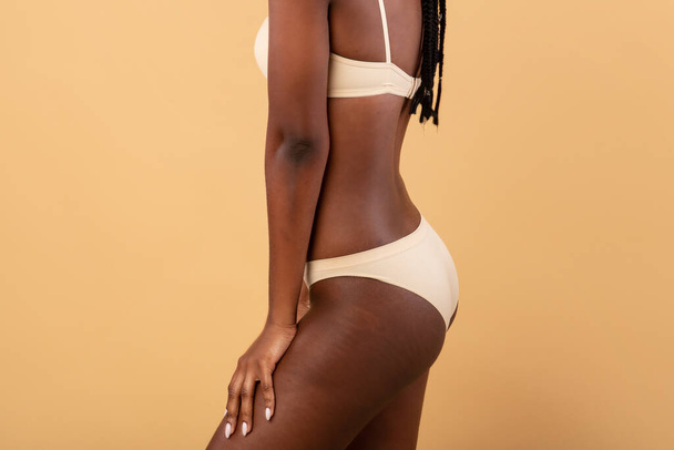 Przycięty obraz nierozpoznawalnej AfrykankiKobieta z gładką skórą pozowanie w bieliźnie - Zdjęcie, obraz