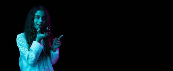 Giovane bella ragazza che parla al telefono isolato su sfondo scuro in luce al neon - Foto, immagini