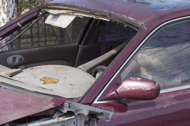 Egy régi autó a roncstelepen. Törött szélvédő és műszerfal. Oldalnézet. - Fotó, kép