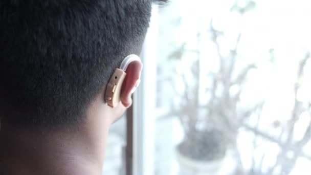 Concepto de audífono, un joven con problemas auditivos. - Metraje, vídeo