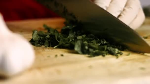 Picar perejil con un cuchillo en una tabla de madera. Proceso de cocción de patatas asadas al horno perfectas. Cronograma - Imágenes, Vídeo