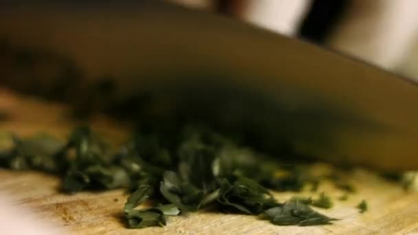 Petersilie mit einem Messer auf einem Holzbrett hacken. Prozess der Zubereitung perfekter Bratkartoffeln im Ofen. Zeitraffer - Filmmaterial, Video