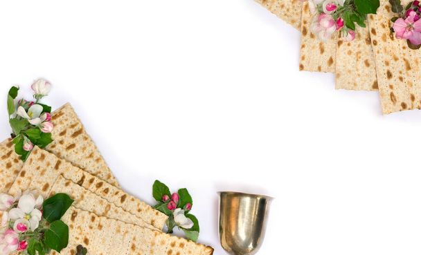 Matzo, bol en argent et fleurs roses pommier pour la célébration de la Pâque sur fond blanc avec espace pour le texte. Vue de dessus, plan plat - Photo, image
