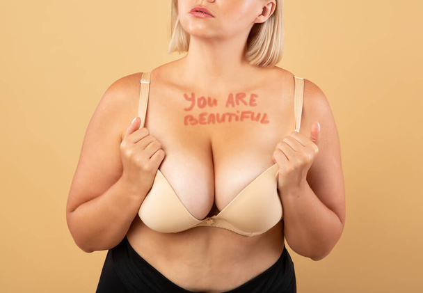 Ви красивий мотиваційний напис на грудях пишної жінки в нижній білизні
 - Фото, зображення