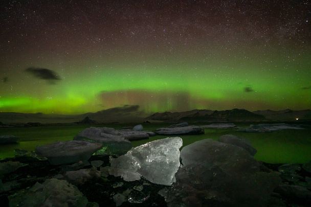 Incrível atividade Aurora Borealis acima da costa na Islândia - Foto, Imagem