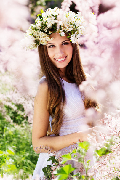 Beautiful girl on the nature in wreath of flowers - Fotó, kép
