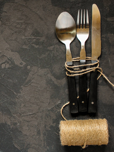 faca, garfo e colher, utensílios de mesa sobre fundo escuro - Foto, Imagem