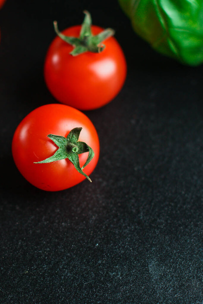 rode tomaten op donkere houten ondergrond met kopieerruimte - Foto, afbeelding
