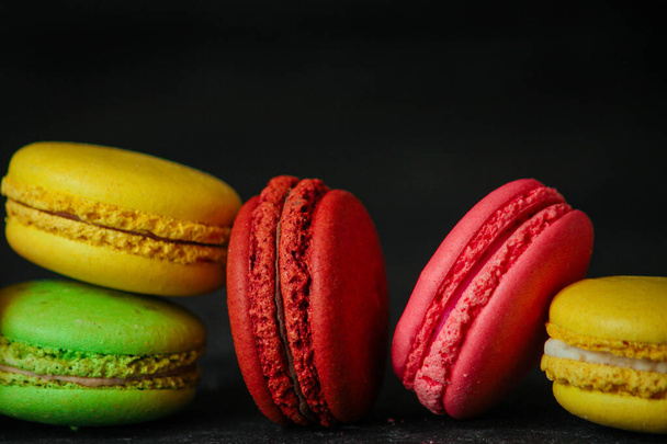 close-up view of sweet tasty colorful macaroons on a black background - Фото, зображення