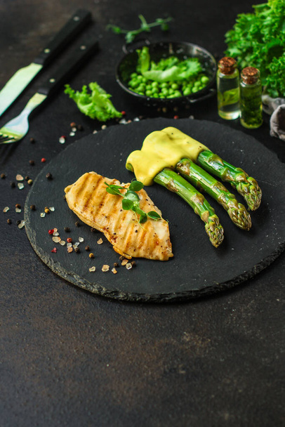 piece of fish with asparagus on dark background - Foto, Imagem