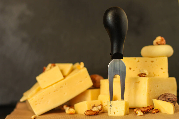 various types of cheese and nuts on a wooden board  - 写真・画像