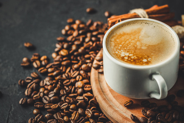 fermer tasse de café avec des grains sur fond noir - Photo, image