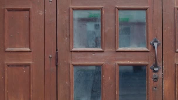 Une vieille porte rouge avec une vieille poignée de porte rouillée et des fenêtres sales - Séquence, vidéo