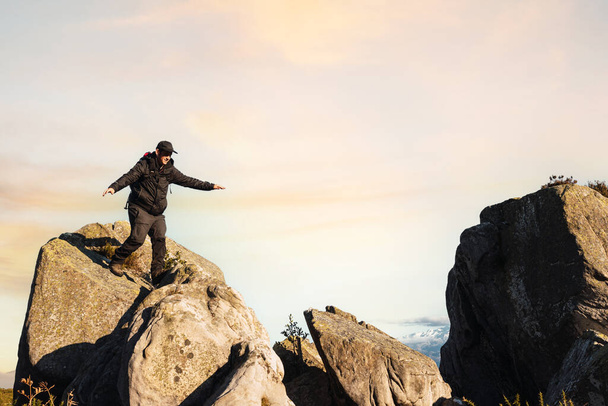 turista sestupující z vrcholu hory při západu slunce. horské aktivity. víkendový výlet - Fotografie, Obrázek