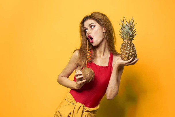 mujer con piña y coco cóctel frutas exóticas estilo de vida de verano fondo amarillo - Foto, imagen