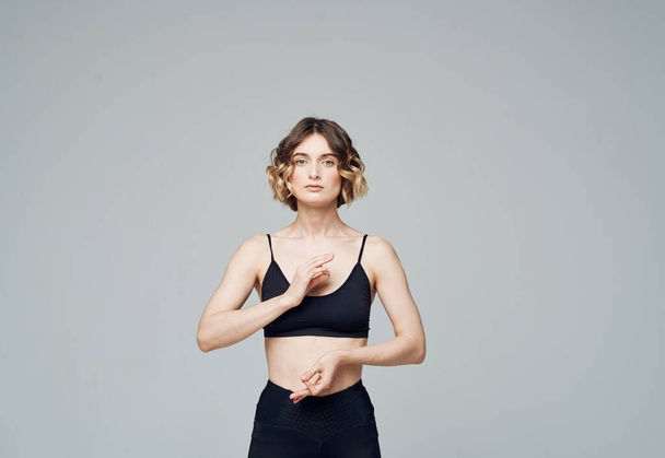Žena s krátkými vlasy v džínách a tričkem se zabývá sportovní fitness jóga asanas - Fotografie, Obrázek