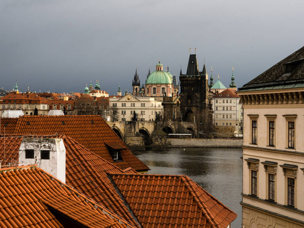 Rooftops of Mala Strana neighborhood with view of Charles Bridge at the background - Photo, Image
