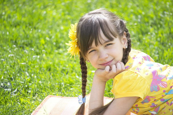 het kleine meisje in de tuin in de zomer - Foto, afbeelding