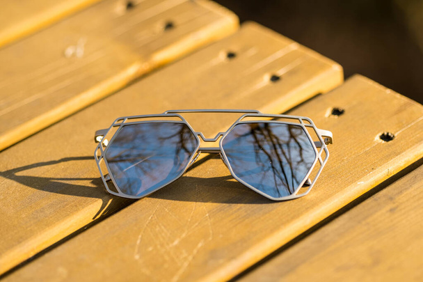 Футуристична модель сонцезахисних окулярів має спеціальний дизайн з великими срібними лінзами крупним планом зйомка зовні в літній день. Вибірковий фокус
 - Фото, зображення