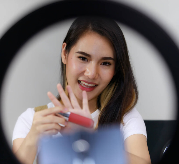 Smiling Asian Woman Live Broadcast Πώληση αξεσουάρ μακιγιάζ και κραγιόν με κάμερες. Έννοια των online αγορών πωλήσεων - Φωτογραφία, εικόνα