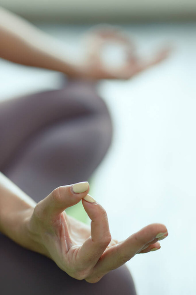 Hand of woman präsentiert Geste im Yoga-Praxisstil, Lotus-Pose, die Basis für einen Neuling. - Foto, Bild