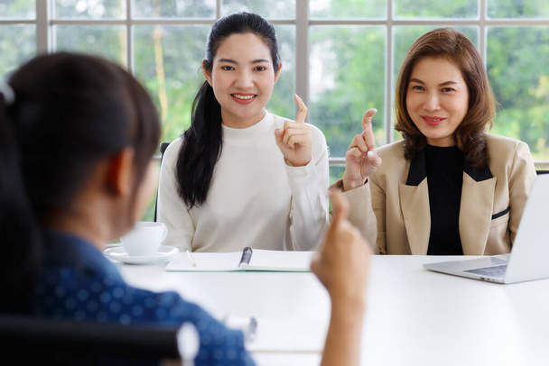 Gehörlose Übersetzerin bringt zwei Geschäftsfrauen bei, Handzeichen zu benutzen und zu verstehen. - Foto, Bild