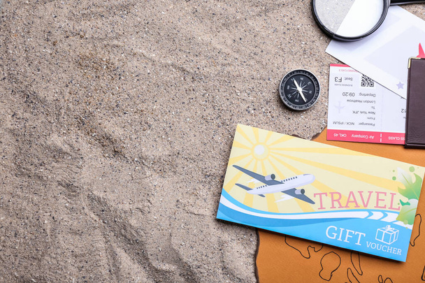 Set reisartikelen en cadeaubonnen op zand - Foto, afbeelding
