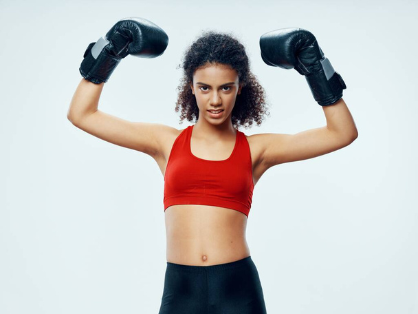 ボクシンググローブのスポーツ女性赤いTシャツとレギンススポーツ - 写真・画像