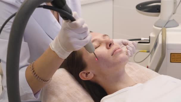 El procedimiento de rejuvenecimiento de la cara femenina con un láser. Tratamientos de belleza - Imágenes, Vídeo