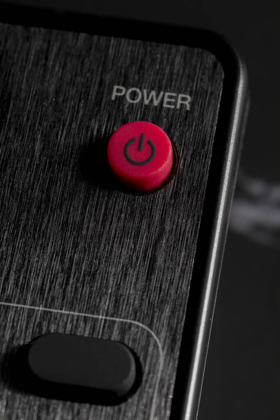 Close-up do botão Power (ligado - desligado) no controle remoto para TV e áudio na cor preta. - Foto, Imagem
