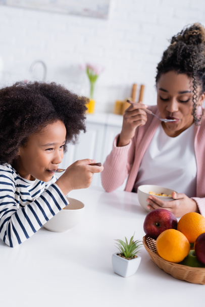 Αφροαμερικάνα μητέρα και κόρη τρώνε νόστιμο κορν φλέικς για πρωινό - Φωτογραφία, εικόνα