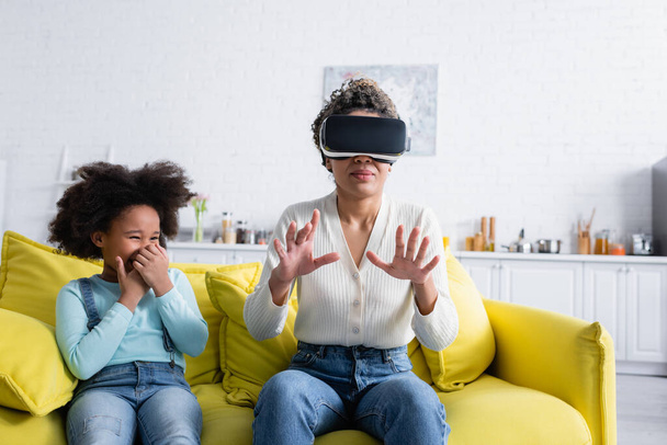 african american woman gesturing in vr headset near laughing daughter - Photo, Image