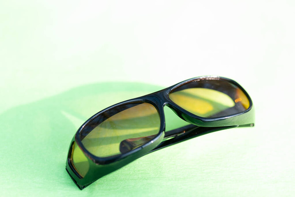 Солнечные очки с желтыми линзами специально для вождения. Съемки в летний день на улице крупным планом - Фото, изображение