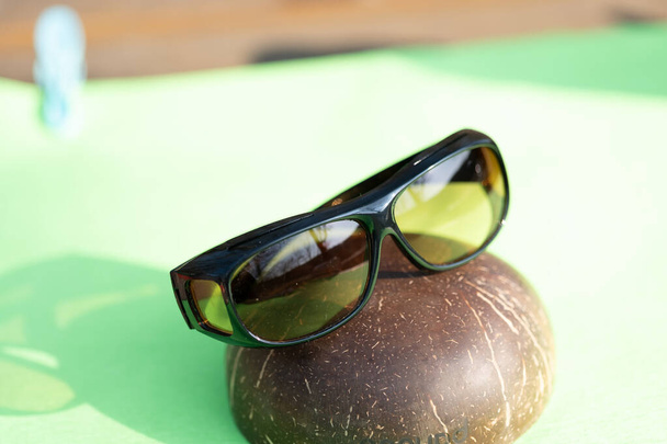 Okulary przeciwsłoneczne z żółtymi soczewkami specjalne do jazdy. Kręć w letni dzień na zewnątrz zbliżenie - Zdjęcie, obraz