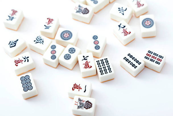 Viele weiße Kacheln aus Mahjong auf weißem Hintergrund verstreut. - Foto, Bild