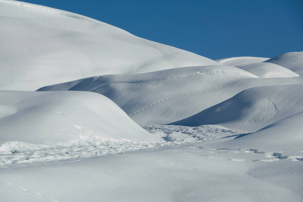 Winterlandschaft mit Schneebänken, an einem sonnigen Tag nach einem Schneesturm                              - Foto, Bild