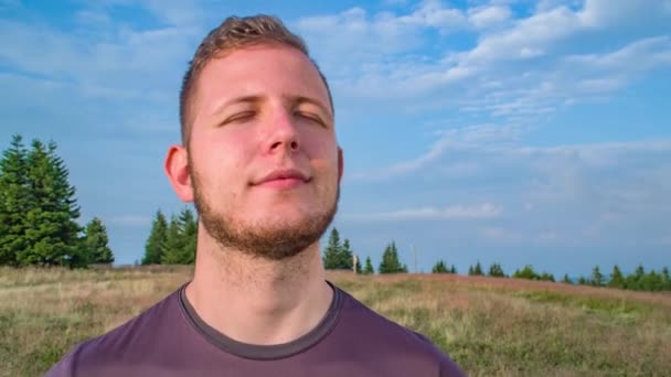 Zblízka záběr zamyšleného muže stojící klidně po túře do hor - Záběry, video