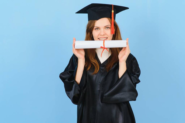 Beautiful woman wearing graduation cap and ceremony robe holding degree looking positive and happy standing and smiling with a confident smile. - Φωτογραφία, εικόνα