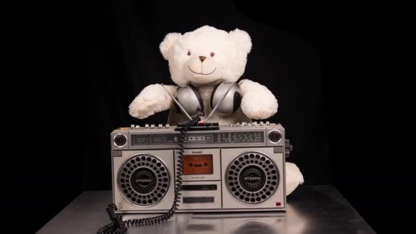 Медведь Тедди слушает музыку на геттобластере - Кадры, видео