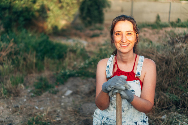 Porträt einer jungen Bäuerin auf dem Land mit den letzten Lichtstrahlen. Der junge Gärtner kümmert sich um das ökologische Feld. landwirtschaftliches Konzept - Foto, Bild