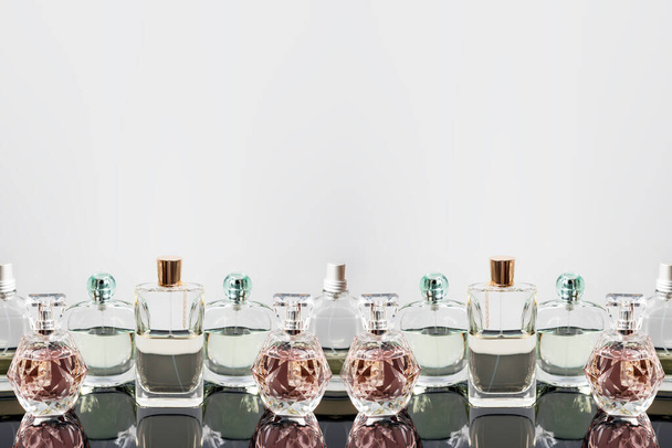 Frascos de perfume diferentes con reflejos. Perfumería, cosméticos. Espacio libre para texto. - Foto, imagen