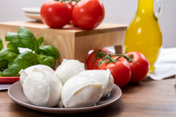 Колекція сиру сиру, маленькі білі м'які м'які кульки моцарелла, подані з червоними помідорами і свіжим зеленим базилем з Італії. - Фото, зображення