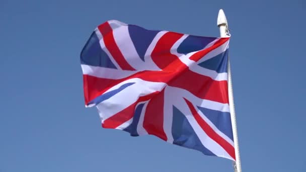 Yhdistyneen kuningaskunnan lippu lepattaa sinistä taivasta vasten hidastettuna - Materiaali, video