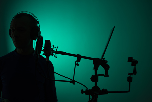 Voiceover artist actor recording voice overs in professional audio studio with large diaphragm cardioid microphone. - Photo, Image