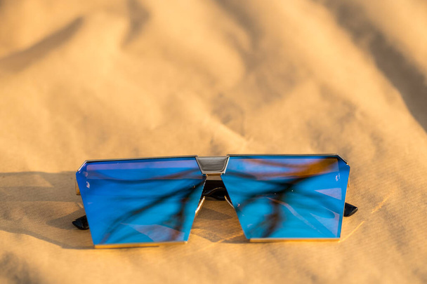 Oversized zonnebril model met blauwe lenzen schieten buiten in een zonnige dag close-up. Selectieve focus - Foto, afbeelding